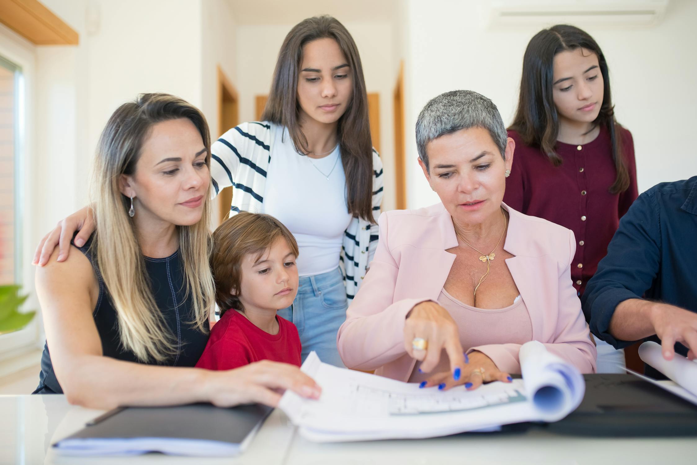 Family group reviewing documents with a senior living advisor in a bright, modern room