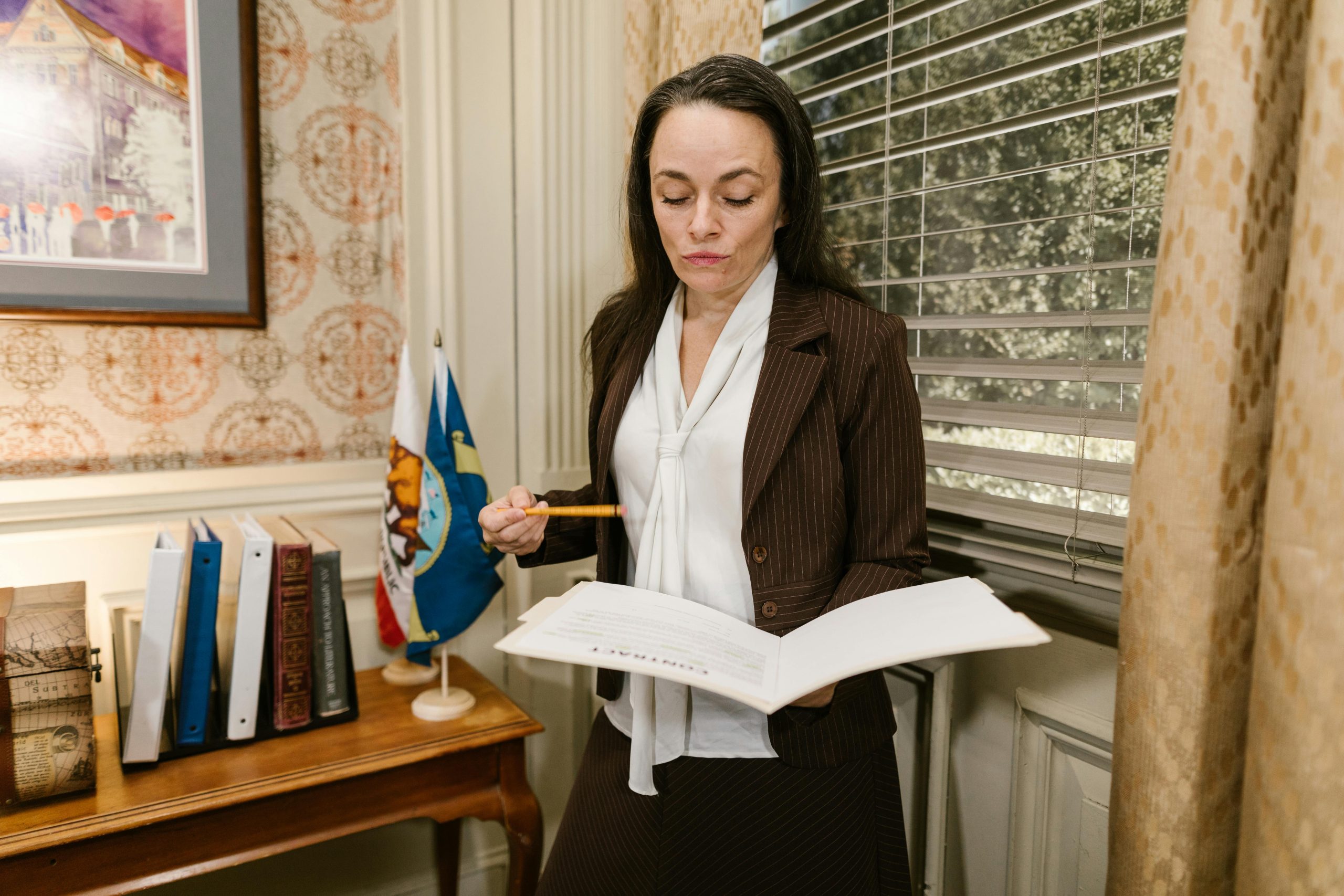 Middle-aged woman sitting in a government office waiting area, holding a folder of documents, looking calm and prepared